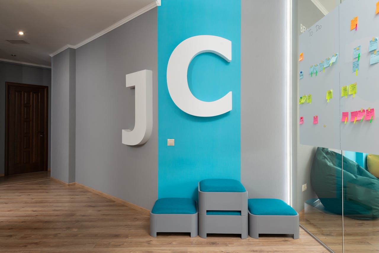 team-01 Contemporary office lobby featuring large decorative letters and glass wall with colorful notes.